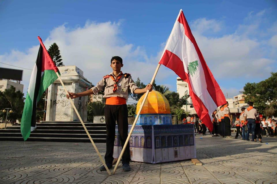 الكشافة الفلسطينية تحيي انتصار تموز برفع صور قادة المقاومة اللبنانية