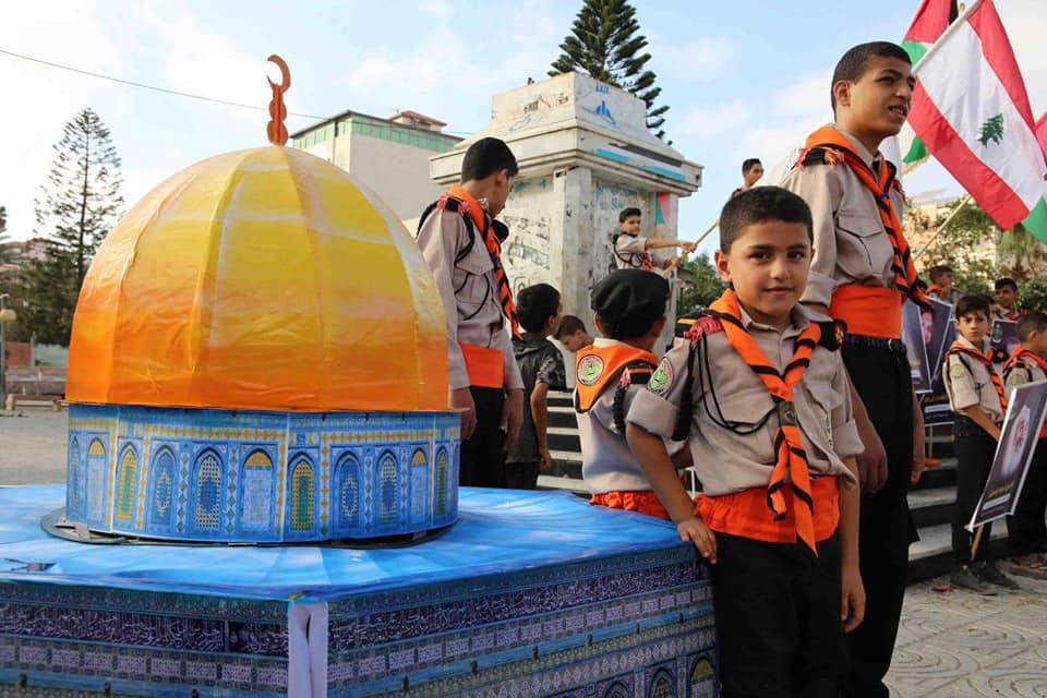 الكشافة الفلسطينية تحيي انتصار تموز برفع صور قادة المقاومة اللبنانية